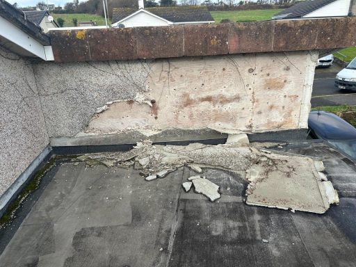 Damaged roof with peeling paint and exposed materials.